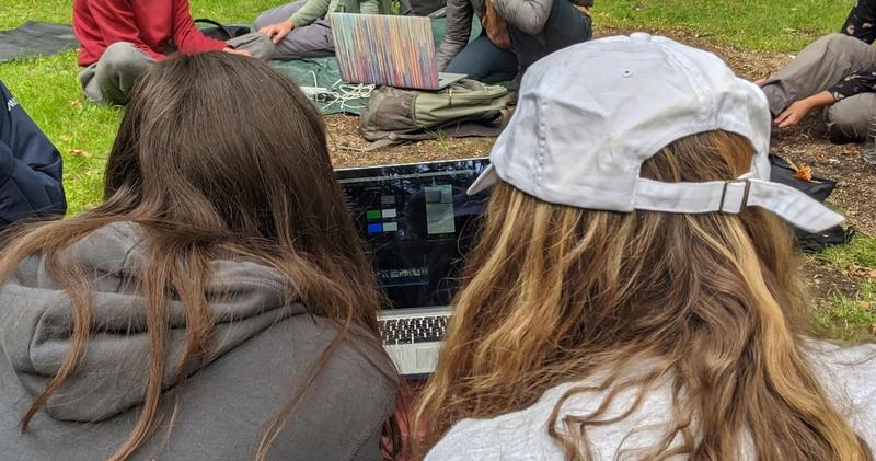 Photo of two people sharing a laptop to edit a video