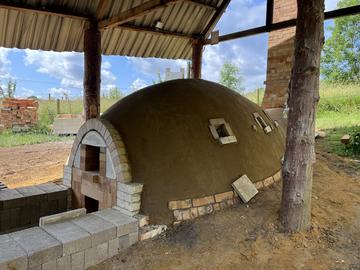 The kiln has a rounded shape, with square stoking holes along its sides.