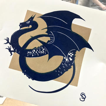 A printed card of a blue dragon on a gold background